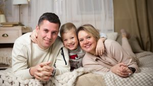 a man and woman with a couple of children on a bed